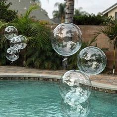 some clear bubbles floating in the air near a swimming pool