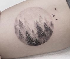 a woman's thigh with trees and birds in the sky on her right side