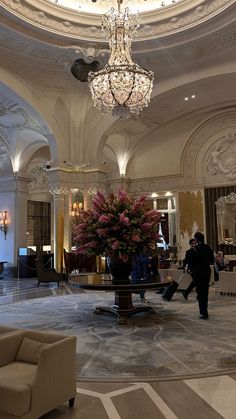 a lobby with chandelier and flowers in the center