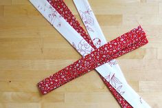 two red and white pieces of fabric on a wooden surface with one piece cut out