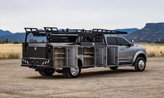 a silver truck parked in the middle of a dirt field