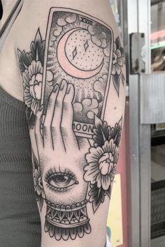 a woman's arm with a clock and flowers on it, in black and white