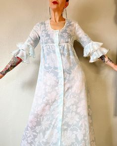 "Beautiful Vintage 1960's ice blue and white sheer floral organza full button front empire waist housedress/maxi dress with double ruffle trumpet sleeves, ruffle hem, floral lace trim and single side pocket, by Regence - Made in France. Ethereal beauty.  🕊️🕊️🕊️ Fits S/M (I'm about a M), but please use measurements as fit guide. 15\" shoulder  18.5\" bust (on the half)  17\" empire waist (on the half)  24\" hip (on the half)  16.5\" sleeve  56.5\" length  Unlined - sheer Center front covered button closures  87/13 poly/cotton organza  Floral lace trim throughout  Double ruffle trumpet sleeves  Empire waist with gathering  Single right side pocket  Ruffle hem  Excellent vintage condition" Trumpet Sleeves, Trumpet Sleeve, House Dress, Ethereal Beauty, Side Pocket, Dress Clothes For Women, Ice Blue, Empire Waist, Ruffle Hem