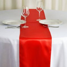 the table is set with two wine glasses and one empty glass on top of it