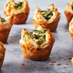 several mini quiches with spinach and cheese in them