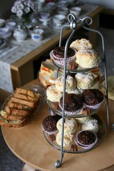 three tiered trays filled with cupcakes and muffins on a table