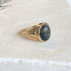 A Fine Vintage 9 carat Gold signet ring with a cabochon Bloodstone. A timeless piece that is bold and classic, a great ring for everyday wear. The detailing down the shoulders really finish it perfectly. CONDITION: Very good condition, please see photos for more detail STONE FACE: 10mm x 8mm RING SIZE: UK: I 1/2 | US: 4 1/2 RING WIDTH (SMALLEST): 2mm SETTING AND STONE HEIGHT: 5mm WEIGHT: 2.5 grams