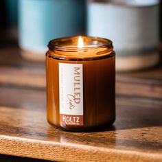 a lit candle sitting on top of a wooden table