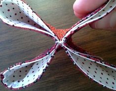 someone is holding an origami piece with red and white polka dots on it