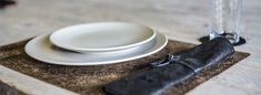 a place setting with white plates and black napkins