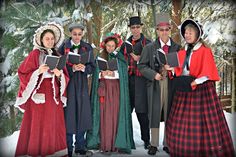 a group of people standing in the snow with some dressed up and holding musical instruments