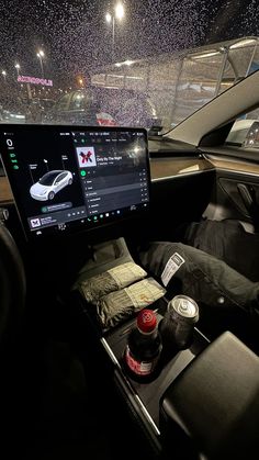 the dashboard of a car with drinks and snacks in it