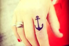 a woman's hand with an anchor tattoo on it