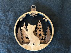 a wooden ornament with an image of a wolf in the woods