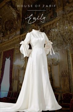 a white dress on display in front of a chandelier