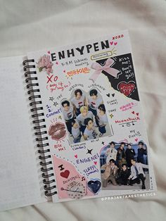 an open notebook with stickers and pictures on the cover is laying on a bed