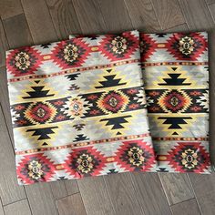 two colorful rugs sitting on top of a wooden floor