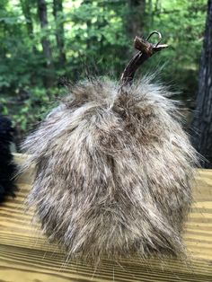 a furry object sitting on top of a wooden table