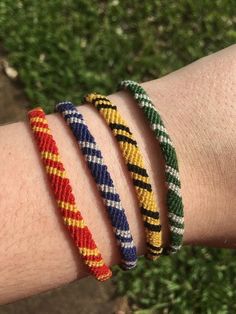 three bracelets on someone's arm with grass in the background