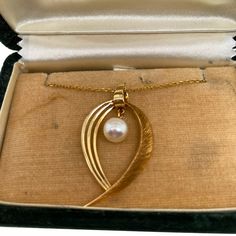 This is part of Chairish’s Fine Jewelry assortment.  A fine vintage, 14K Gold Japanese Mikimoto cultured pearl pendant on chain. The pendant has a Florentine finish on one side and is polished smooth on the other. The pendant has a suspended 6mm beautiful Akoya pearl. The back of the pendant, as well as the clasp, is stamped K14 and the Mikimoto makers mark- M in an oyster shell. The necklace comes in a vintage Mikimoto box. Condition is excellent   Dimensions- Chain Length: 19"; Pendant dimensi Formal Vintage Akoya Pearl Necklace, Vintage Gold Akoya Pearl Necklace, Vintage Akoya Pearl Necklace, Vintage Akoya Pearl Necklace For Anniversary, Vintage Pearl Charm Jewelry For Anniversary, Vintage Jewelry With Pearl Charm For Anniversary, Vintage Heart Pendant Jewelry With Pearl, Antique Pearl Necklace With Pearl Pendant For Formal Occasions, Vintage Pearl Pendant Jewelry For Evening