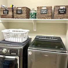 a washer and dryer sitting next to each other in a room with baskets on the shelves