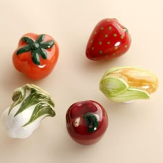 four different types of fruits and vegetables on a white surface with the words tomatoes, strawberries, cabbage, apple, tomato