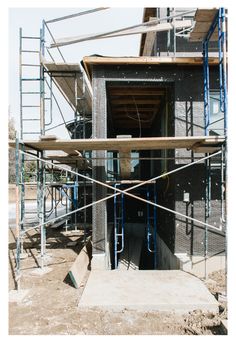 an unfinished building with scaffolding around it and stairs leading up to the entrance