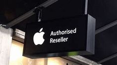 an apple store sign hanging from the ceiling