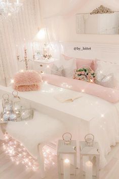 a white bed topped with pillows and lights