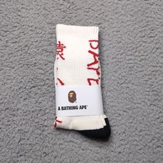 A Bathing Ape Crew Socks Japanese Writing Mens Womens Unisex Size: One Size Fits All Color: Off White Red Black Brand New In Packaging. Fast Shipping! 1 Day Shipping And Handling. Casual Breathable Red Socks, Casual Red Breathable Socks, Sports Cotton Socks With Letter Print, Cotton Socks With Letter Print For Streetwear, White Sports Socks For Winter, Casual Cotton Letter Print Socks, White Winter Sports Socks, White Breathable Cotton Socks, Casual Red Socks For Streetwear