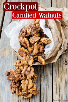 some food is in a paper bag on a wooden table and next to it are walnuts