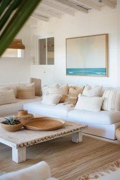 a living room filled with white furniture and pillows