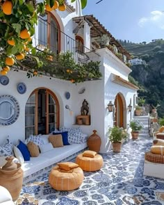 an outdoor patio with oranges and potted plants on the roof, surrounded by blue and white tiles