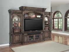 a large entertainment center with a flat screen tv on it's stand and shelves