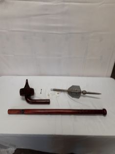 an assortment of tools are displayed on a white tableclothed surface, including a cane and other items