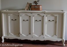 an old white cabinet with some books on top