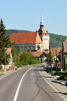 an empty street in front of a church with a steeple on the top of it