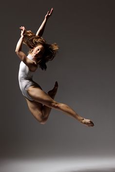 a woman is jumping in the air with her legs spread