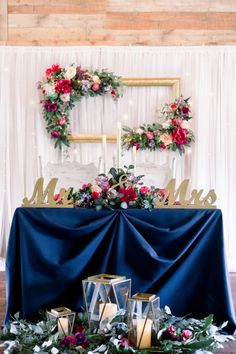 a table topped with candles and flowers next to a sign that says mr and mrs