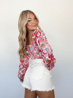 Experience a timeless fusion of fashion and comfort with the Retro Groove Top. Crafted from soft satin with a stretchy smocked back panel, this cropped piece presents a unique look with a floral print, square neckline, and balloon sleeves. Perfect for making a statement, it's fun, chic, and sure to elevate any ensemble. 100% Polyester Hand wash cold separately. Floral Print Stretch Cropped Top, Stretch Floral Print Cropped Top, Stretch Cropped Floral Print Crop Top, Chic Spring Crop Top With Elastic Waistband, Spring Pink Smocked Bodice Crop Top, Fitted Pink Top With Elastic Waistband, Spring Pink Printed Crop Top, Chic Floral Print Crop Top, Pink Smocked Bodice Crop Top For Summer