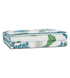 two sheets with blue and green floral designs on the bottom, one is folded up