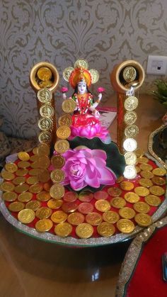 a small statue sitting on top of a table filled with gold coins