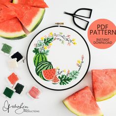 watermelon slices and other fruit are on the table next to a cross stitch pattern