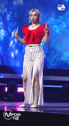 a woman standing on top of a stage with her hands in the air while wearing high heels