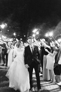 a bride and groom holding sparklers as they walk down the aisle at their wedding