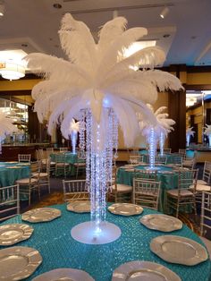 the centerpieces are decorated with white feathers and blue tablecloths for an elegant event