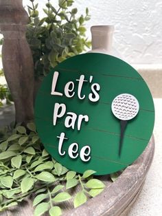 there is a sign that says let's par tee and a golf ball on it