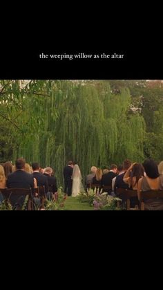 the wedding ceremony is being held in front of a willow tree and people are sitting on chairs