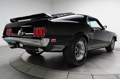 a black mustang muscle car on display in a showroom