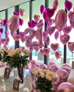 balloons and flowers are arranged in front of a window with the number twenty five on it